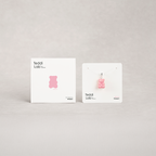 Pink gummy bear-shaped product on a white card with 'Teddi Lab' branding against a light gray background